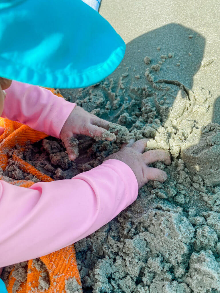 baby playing in the sand